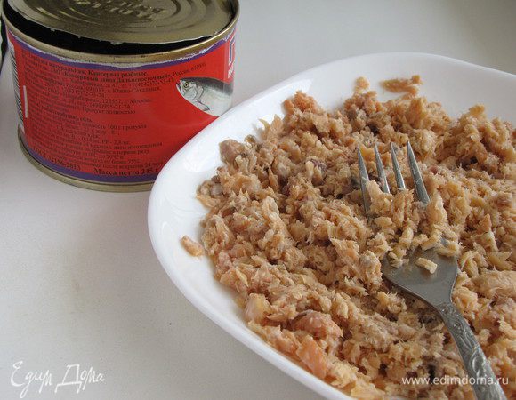 Рыбу из банки выложить на тарелку и размять при помощи вилки.