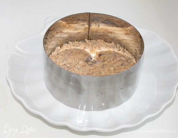 В плоскую вазу или кулинарное кольцо выложить первым слоем рыбу. Слегка примять вилкой.