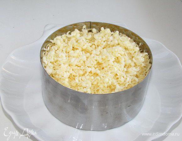 Затем тертый на мелкой терке сыр и сверху немного замороженного сливочного масла натереть на мелкой терке. На все слои, кроме сыра, наносить тонкую сетку майонеза. Салат убрать в холодильник на пру часов, чтобы пропитался.