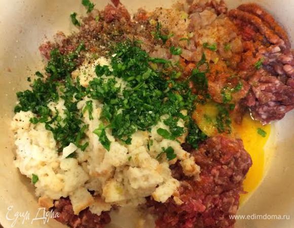 Духовку нагреть до 180°C. Лук мелко порезать и потушить до золотистого цвета. Хлебную крошку залить молоком. В миске смешать: фарш, зелень, лук, хлебную крошку, паприку, соль, перец, яйцо и все хорошо выместь.