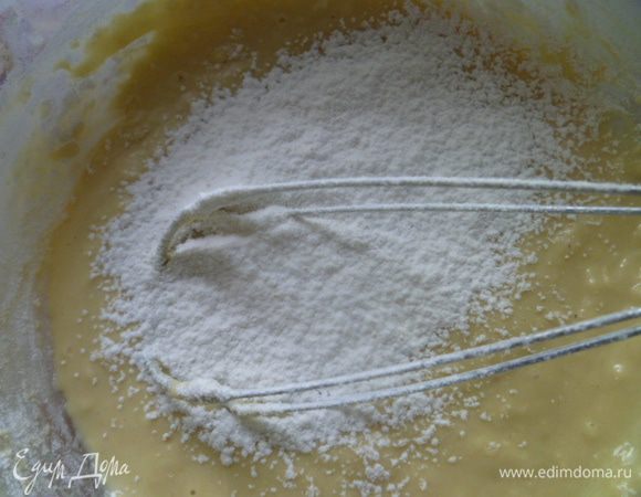 Добавляем половину просеянной муки и понемногу, тщательно вымешиваем.