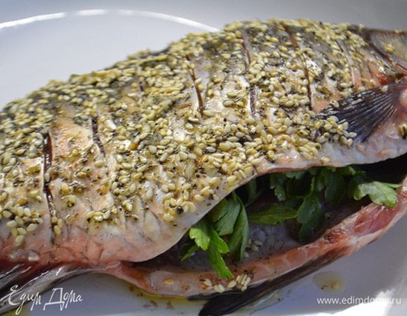Форму смазать маслом и уложить рыбу, брюшко нашпиговать веточками петрушки. Запечь при температуре 200°С, 40 минут.