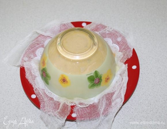 Заверните марлю, сверху положите тарелку, а на нее поставьте груз. Поставьте в прохладное место на сутки.
Разверните марлю и переверните пасху на блюдо. 