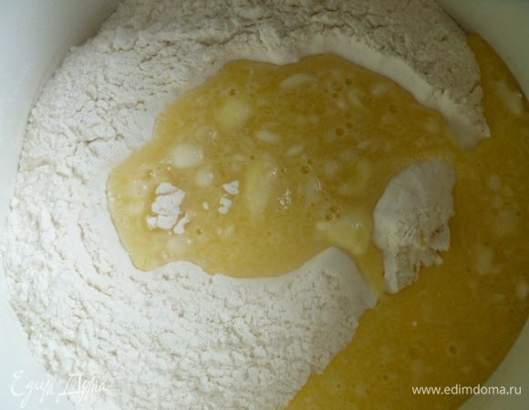 В отдельную посуду просеиваем 3 ( 250 мл) стакана муки и сверху выливаем половину яичной смеси.