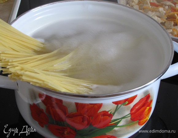 Первым делом поставить на огонь кастрюлю с водой. Когда вода закипит засыпать спагетти и варить до состояния альденте.