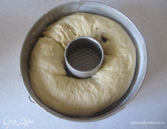 Свернуть пласт теста в длинный рулет и поместить его швом вниз в предварительно смазанную сливочным маслом форму с центральным отверстием. Отправить в предварительно разогретую до 180°C духовку на 40-50 минут. Время выпечки определяйте по своей духовке.
