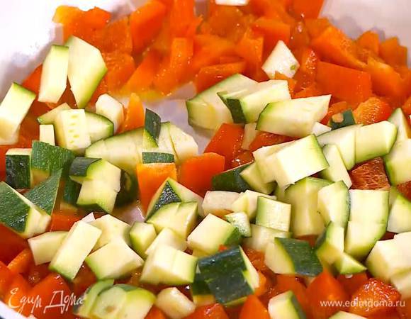 Цукини нарезать небольшими кубиками и выложить к перцу.