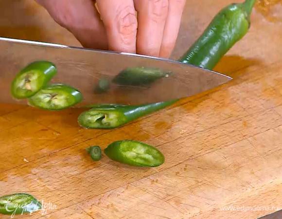Перец чили порезать тонкими кольцами и отправить к овощам.