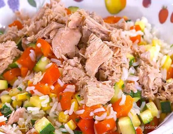 Переложить рис с овощами в тарелку, сверху разложить кусочки тунца.