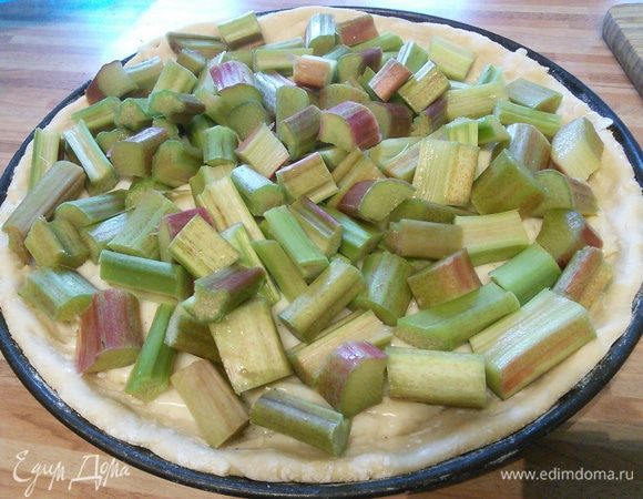 Пока пудинг остывает, раскатать тесто двумя см больше объема вашей формы (у меня 26 см в диаметре) и при помощи скалки перенести тесто в форму. Разровнять, делая бортики. Теперь время заполнить тарт пудингом. Он должен быть еще теплым, потому что именно в этом случае он имеет наиболее подходящую консистенцию: уже не жидкий, но еще не застывший. 