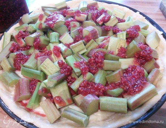 Духовку разогреть до 175°С. Ревень помыть и нарезать на кусочки размером 1 см. Я никогда не очищаю молодой ревень, так лучше сохранять его привлекательный розовый цвет. Разложить ревень в произвольном порядке поверх пудинга. Ревень в этот раз оказался зеленый и я добавила 3 ст. л. малины, перетертой с сахаром. 