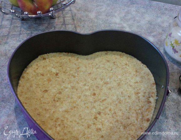 Готовим корж: печенье измельчаем в крошку. Заливаем предварительно растопленным сливочным маслом, размешиваем и полученную массу равномерно утрамбовываем в форму с высокими бортами (желательно, чтобы борт формы был съемный). Ставим в холодильник на время пока готовим заливку.