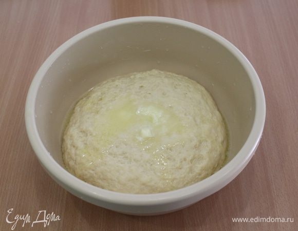 Сливочное масло растопить, слегка остудить и ввести в тесто, еще раз вымесить, подпыляйте тесто отложенной мукой.