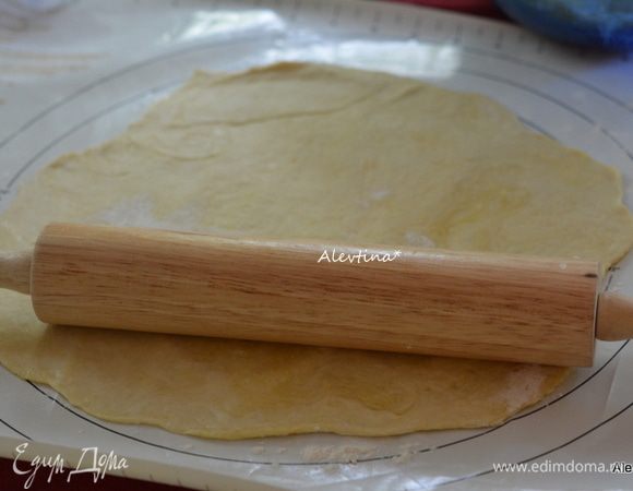 Тесто разделить на 2 части. Раскатать на размер вашей круглой формы, диаметр 23-25 см.
Затем раскатать второй кусок.