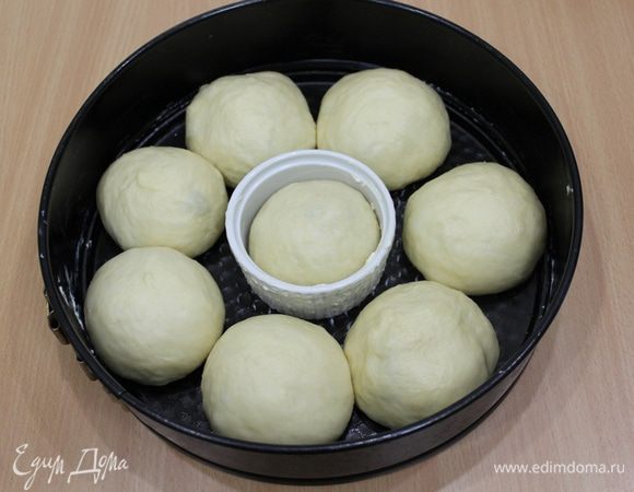 Взять форму на 28-30 см с отверстием посередине (у меня такой нет, пришлось использовать подручные средства), смазать ее маслом, разделить тесто на 10 частей и еще 3 маленьких куличика, придать округлую форму.