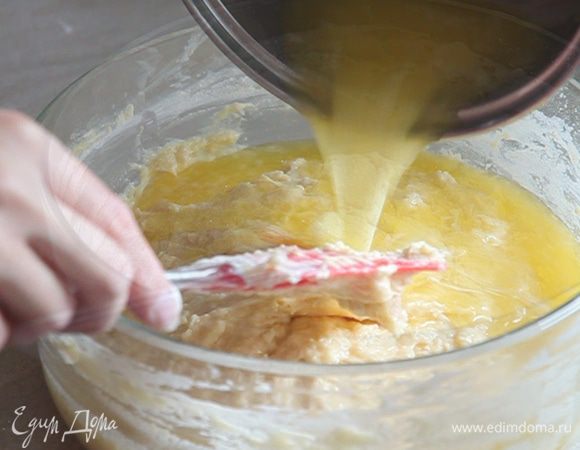 Получаем уже довольно густую массу. В нее добавляем остывшее растопленное сливочное масло. Еще один стакан муки и все перемешиваем ложкой.