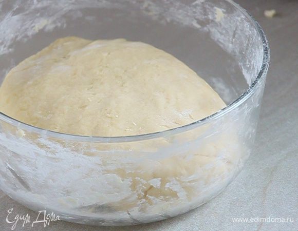 Перекладываем тесто в миску, присыпаем мукой. Накрываем его пленкой, полотенцем и оставляем в теплом месте подниматься где-то на час.