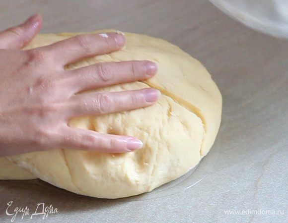 Через час смазываем растительным маслом стол и достаем наше тесто, которое нужно обмять. Обминаем тесто.