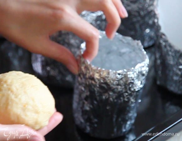 Выставляем на противень подготовленные формы и раскладываем в них тесто. Руками отделяем от теста шарики такого размера, чтоб они заняли 1/3 часть высоты формы. Края отделенного теста загибаем внутрь «шарика». Так верхушка кулича будет гладкой.