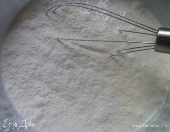 Понемногу вводим просеянную муку с содой и перемешиваем до однородности.