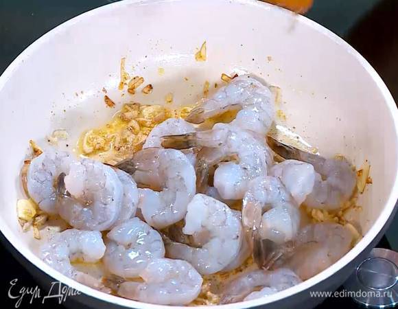 Добавить карри, перемешать, затем выложить в сковороду креветки, еще раз все перемешать и обжарить.