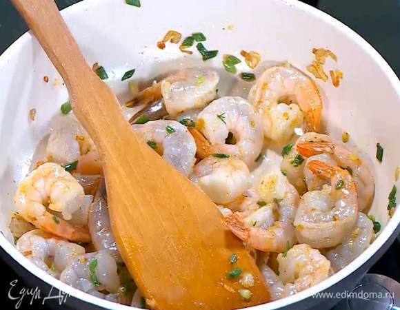 Зеленый лук тонко порезать наискосок, добавить к креветкам, влить половину лимонного сока, посолить и перемешать.