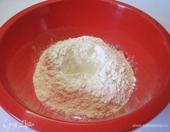 В просеянную муку всыпать сахар, соль и сухие дрожжи.