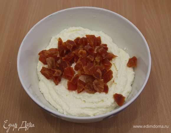 Курагу предварительно замочить в кипятке минут на 10-15 минут, затем обсушить и нарезать на мелкие кусочки, добавить в творожную массу, перемешать.