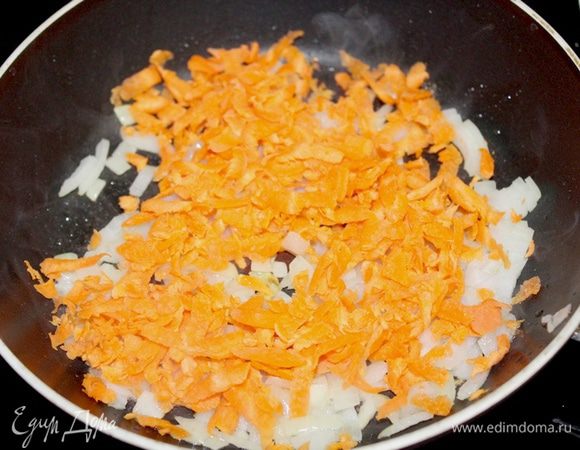 Лук и чеснок мелко нарезать. На среднем огне разогреваем 2 ст.л. оливкового масла. Кладем лук и чеснок и жарим, помешивая, до полупрозрачного состояния, около 4-5 минут. Затем добавляем натертую на крупной терке морковь. Потушить еще 3 минуты.