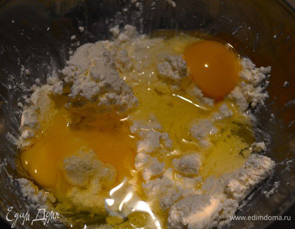 В творог добавить яйца и перемешать.