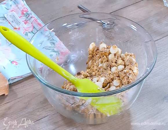 К муке добавить сахарно-яичную массу, измельченные орехи, белый шоколад, кокосовую стружку и вымешать тесто.