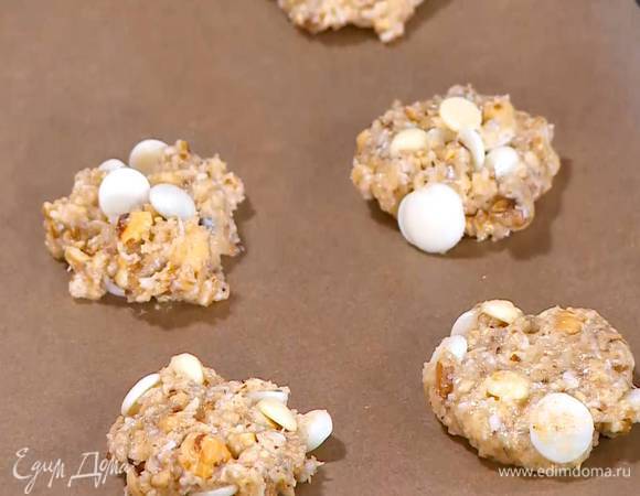 Сформировать из теста небольшие лепешки и выложить на противень, выстеленный бумагой для выпечки.