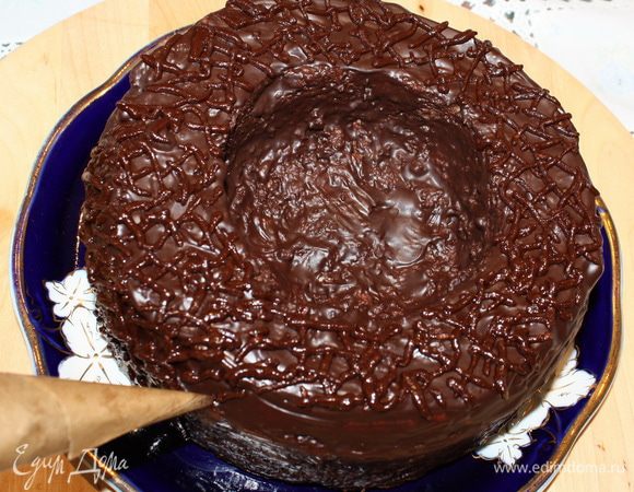 Шоколад растопить на водяной бане. Добавить масло и молоко. Перемешиваем все до однородной массы. Покрываем кулич глазурью при помощи силиконовой кисточки, даем ей полностью застыть. Оставшуюся глазурь перекладываем в корнет, сделанный из пищевой бумаги/пергамента. Хаотично наносим шоколадные полоски на кулич, имитируя плетеное гнездо. 