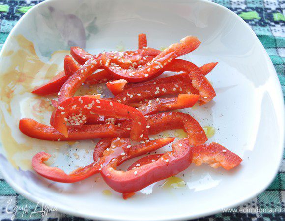 Сладкий перец помыть, почистить от перегородок и семечек. Нарезать довольно крупной соломкой. 
Пробовала сделать нарезку поменьше. Да, удобнее заворачивать рулетики, но с крупной нарезкой получается вкуснее. За то время пока приготовится тесто, перец становится мягче, но сохраняет свою форму, вкус и "мясистость". 
Итак, перец посолить, присыпать кунжутом, сбрызнуть оливковым маслом и перемешать. 