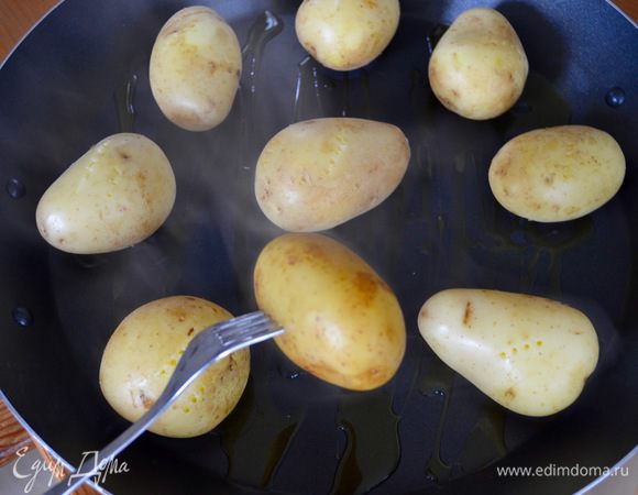 Поднос обильно сбрызнуть оливковым маслом и выложить картофель на небольшом расстоянии друг от друга.