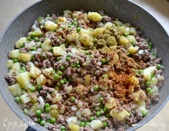 Теперь добавьте горох, имбирь, чили, петрушку, воду, все специи и сок лимона. Доведите до кипения, уменьшите огонь и тушите, пока жидкость не испарится. Готовую начинку полностью остудите.