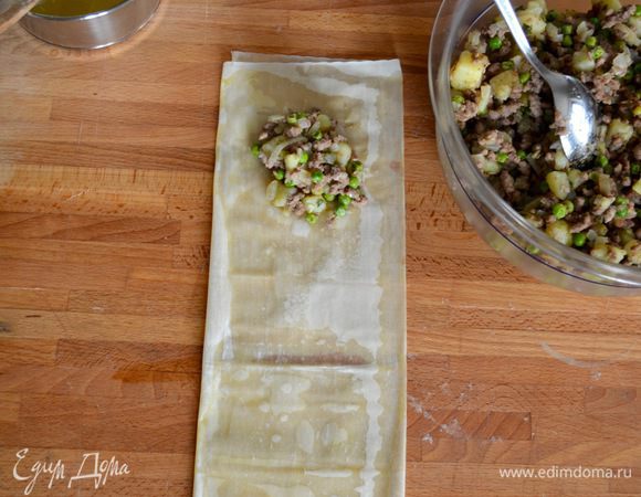 У нас получается длинная полоска теста, в три слоя... Сверху на тесто выложите начинку (примерно 1 ст. л. или чуть больше).
