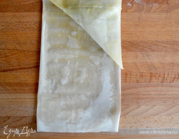 Продолжая сворачивать тесто, доведите этот треугольник до самого конца полоски из теста.