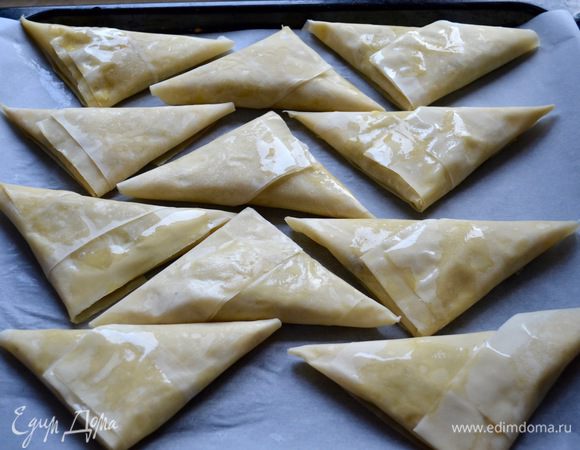 Готовые самосы выложите на противень, застеленный пекарской бумагой. У меня получилось 15 пирожков.