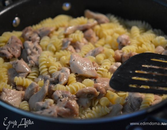 Вернуть на сковороду куриные кусочки. Перемешать и готовить еще 3 мин. Добавить сливочный сыр. Перемешивать до его растворения. Добавить зеленый горошек. Перемешать.