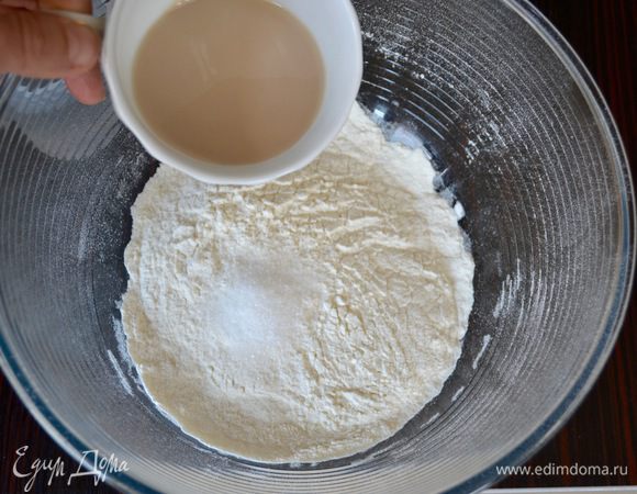 В миску просеять муку и добавить сахар. От общего количества теплой воды отлить 2 ст. л. и развести в ней дрожжи. Добавить сразу к муке и перемешать. Дрожжи можно использовать и сухие (3,6 г), тогда их просто добавить в муку.