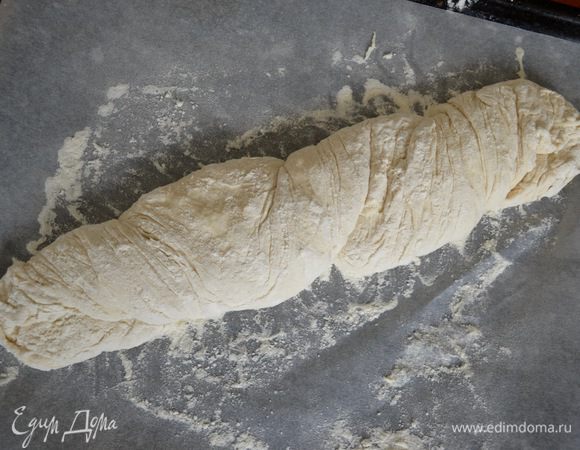 Лично я, помогая себе обеими руками, сначала делаю пару закруток теста с одного конца, а затем также пару закруток теста вокруг себя с другой стороны. Вот и все! 
Духовку предварительно разогреть до 240°С. Как только духовка прогреется и достигнет нужной температуры, открыть ее, поставить на дно миску с кипятком, понизить температуру духовки до 200°С и поставить противень с хлебом.