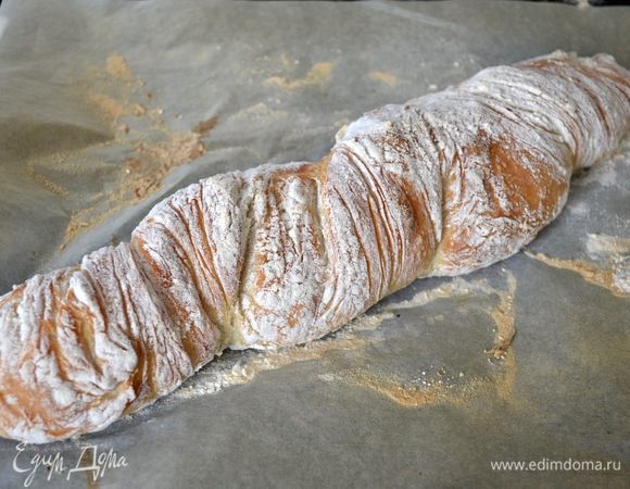 Выпекать буханку около 20 минут. Я выпекала первые 15 минут с водой, а затем убрала миску и еще 5-7 минут пекла без. Готовность хлеба проверить с помощью постукивания по основанию хлеба. Если звук глухой, и такой, как будто хлеб пустой внутри, он готов! Достать хлеб из духовки и остудить на решетке. Я кисточкой удалила излишки муки.