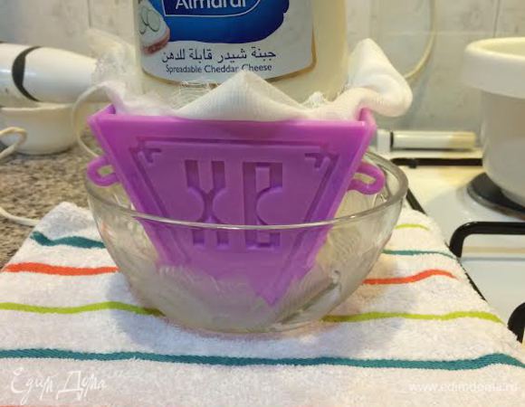 Пасочницу поставить в миску, края марли завернуть и сверху поставить груз. Отправить в холодильник на 12 часов.