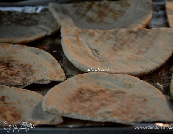 Лепешки нарезать на половинки. Выложить на противень с фольгой.