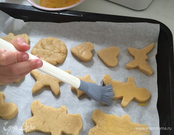Перекладываем на противень, застреленный бумагой и смазываем остатком яйца.
