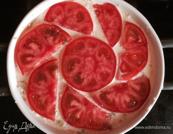 Заливаем полученную массу сливочно-яичной заправкой. Сверху выкладываем помидор, нарезанный тонкими слайсами.