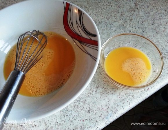Вилкой или венчиком cлегка взбить 2 яйца. Немного, примерно, половинку одного из двух яиц, перелить в отдельную миску и отложить. Это небольшое количество яйца мы оставим для смазки булочек перед выпечкой.