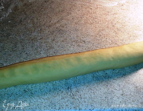 Свернуть рулетом. Рулет разрезать примерно на 10-12 частей. И получаются маленькие рулетики или просто булочки. На противень постелить пергамент и на него выложить булочки. Смазать их взбитым яйцом, которого мы немного оставили еще в начале приготовления теста.