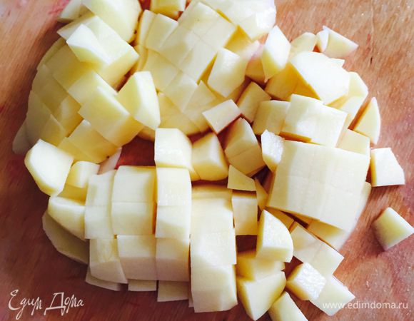 Порезать картошку кубиками и вместе с обжаренной свеклой добавить в кастрюлю.